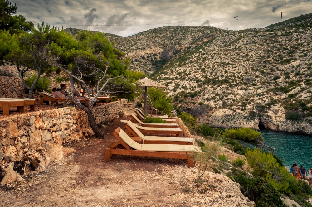 A Greek Sunlounger, a Final Argument: The Frictions of Arrivals