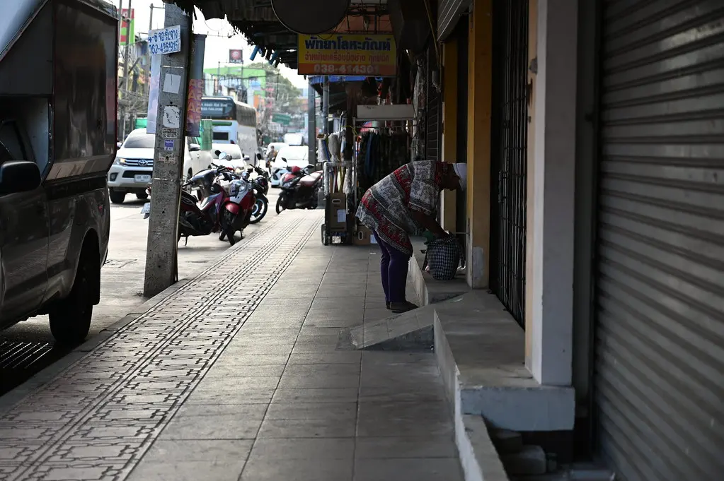 DSC_6416: a woman walking down a street next to parked motorcycles