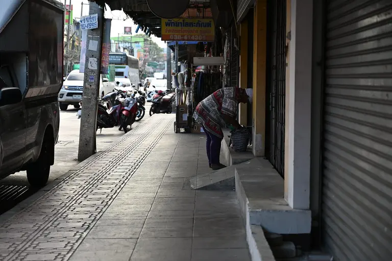 DSC_6416: a woman walking down a street next to parked motorcycles