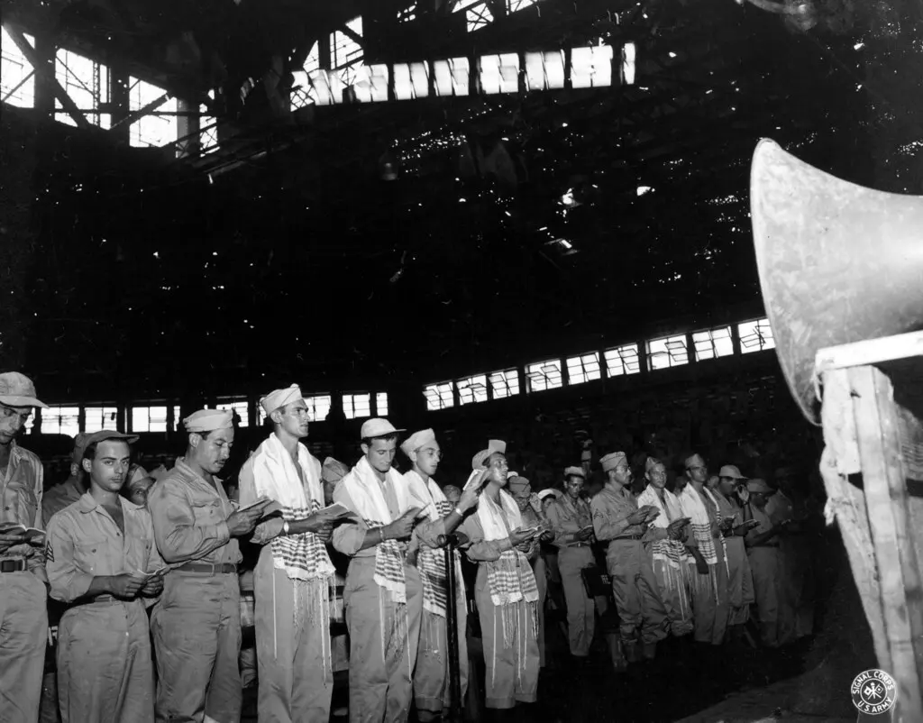 SC 211450 - GIs in front of the stadium are wearing Jewish holy shawls with prayer books in hand while services are going on at Rizal Stadium, Manila. 7 September, 1945.