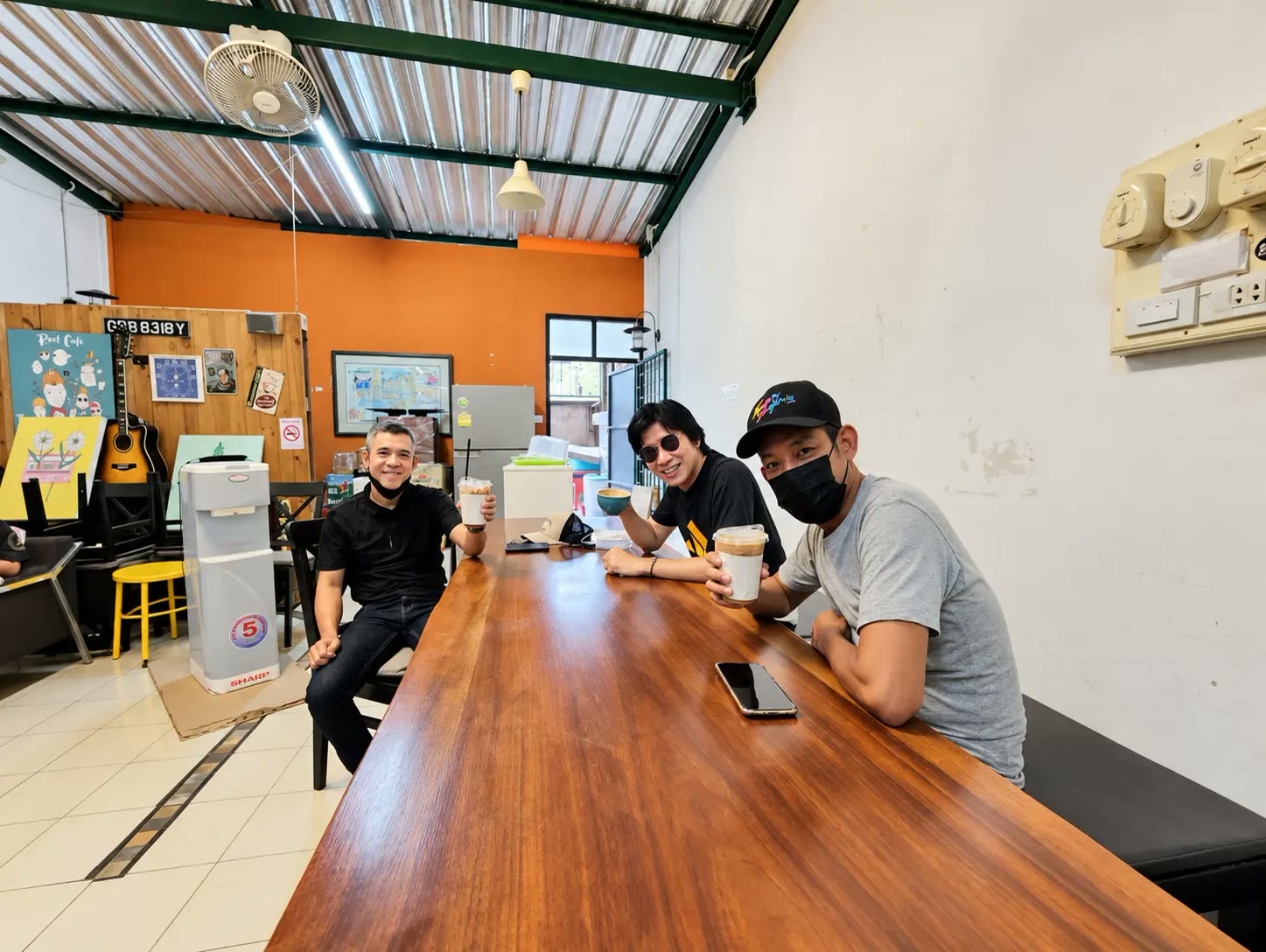 Friends gather around the long wooden table.