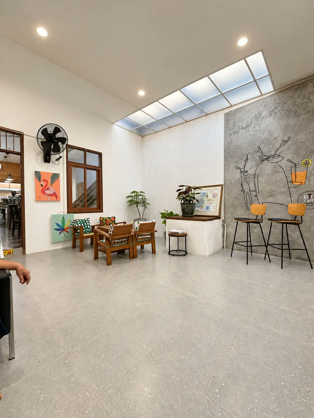 The indoor seating area under a skylight, with hand-drawn wall art.