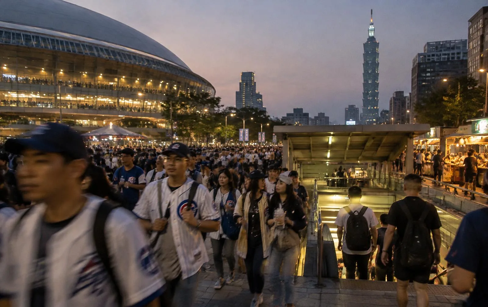 Baseball fans streaming out of the Taipei Dome into the city at dusk